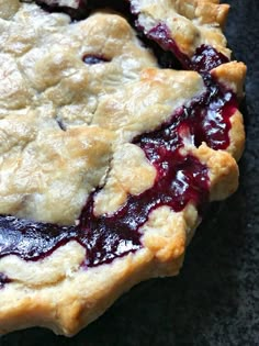 a pie with blueberry topping sitting on top of a table