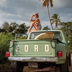 a woman sitting on the back of a pick up truck