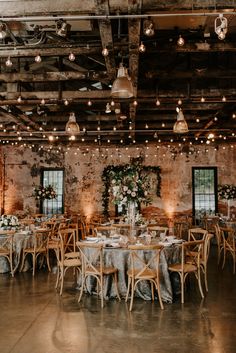 a large room with tables and chairs set up for a wedding reception in an old building