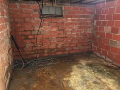 an unfinished room with exposed brick walls and electrical wires in the corner on the floor