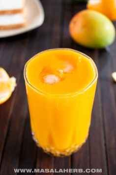 a glass filled with orange juice on top of a wooden table