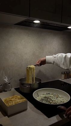 a chef is cooking pasta in a pan on the kitchen counter with other dishes and utensils