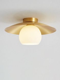 a light that is on the ceiling with a white wall in the back ground behind it