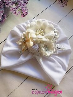 a white hat with flowers and pearls on it