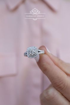 a close up of a person's hand holding a diamond ring