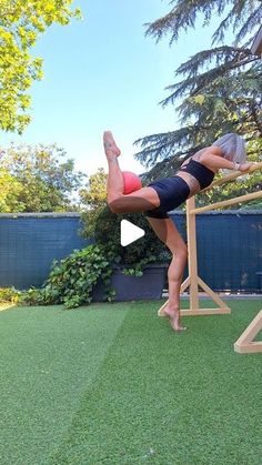 a woman is doing an acrobatic exercise in her backyard