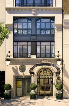 the front entrance to an apartment building with large windows