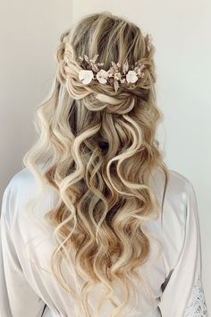 the back of a woman's head with long hair and flowers in her hair