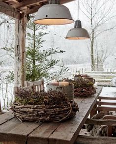 a wooden table topped with a wreath and two lights hanging from it's sides