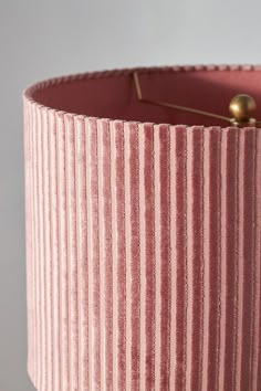 a pink lamp shade with gold pins on it