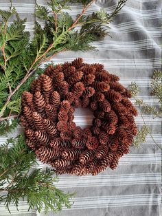 pine cones and evergreen needles are arranged in a wreath