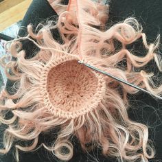 the hair is being crocheted with scissors