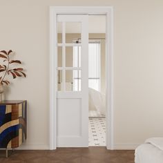 an open door leading to a bedroom with a bed in the corner and a potted plant next to it