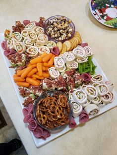 a platter with pretzels, carrots and other snacks