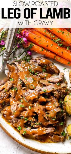 slow roasted leg of lamb with gravy on a white plate next to carrots and potatoes