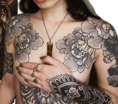 a woman with tattoos on her chest holding a cross