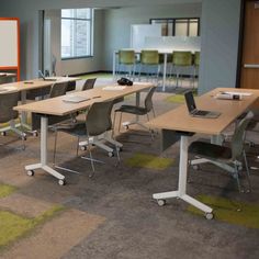 an empty classroom with desks and chairs in front of a projector screen on the wall