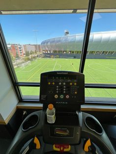 the inside of a bus looking out at a soccer field