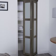 an open closet with white linens in it