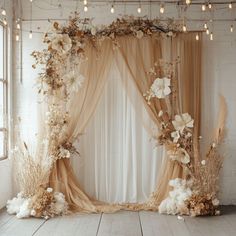 an image of a wedding stage setting with flowers and feathers on the curtained wall