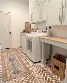 a washer and dryer sitting in a room next to a rug on the floor