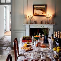 a dining room table is covered with bottles and glasses on it, along with candles