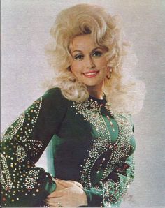 an old photo of a woman with blonde hair wearing a green dress and gold jewelry