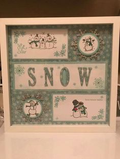 a framed snow sign with some decorations on it