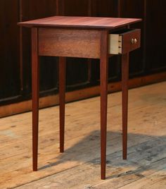 a small wooden table sitting on top of a hard wood floor