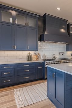 a large kitchen with blue cabinets and white counter tops is pictured in this image from the front view