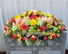 a large bouquet of flowers is placed on top of the headstone for this memorial