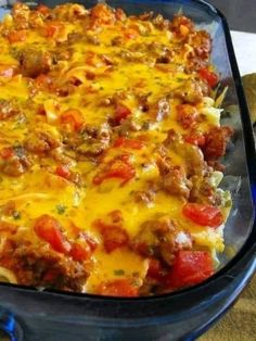 a casserole dish with meat and vegetables in it on a blue serving platter