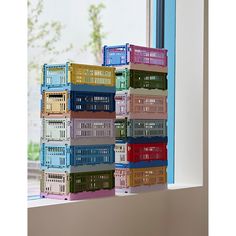 a stack of plastic crates sitting on top of a window sill