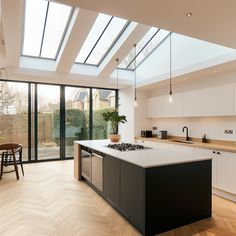 an open kitchen and dining area with skylights