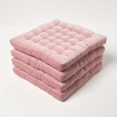 three pink cushions stacked on top of each other