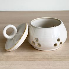 a white cup and saucer sitting on top of a wooden table next to each other