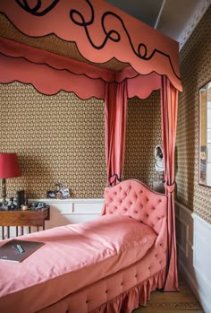 a pink bed sitting in the corner of a room