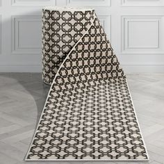 a black and white area rug on the floor next to a wall with two doors