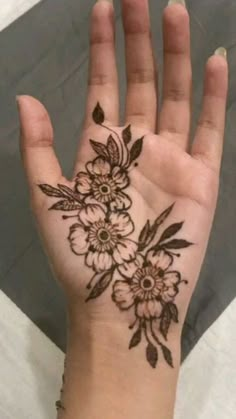 a woman's hand with a flower tattoo on the middle of her left palm