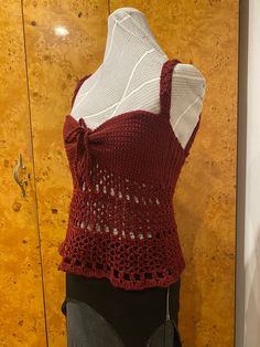 a mannequin wearing a red knitted top with a bow at the back