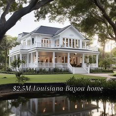 a large white house sitting on top of a lush green field next to a lake