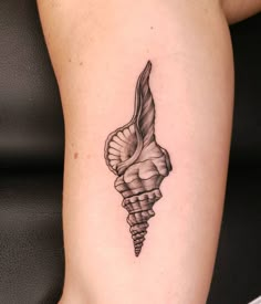 a black and white photo of a tattoo design on the right arm with a sea shell in it