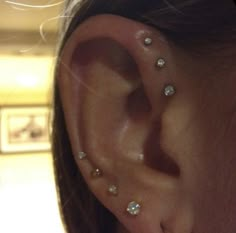 a close up of a person's ear with three different piercings on it