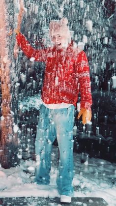 a man standing in the snow holding an umbrella and wearing blue jeans with white socks