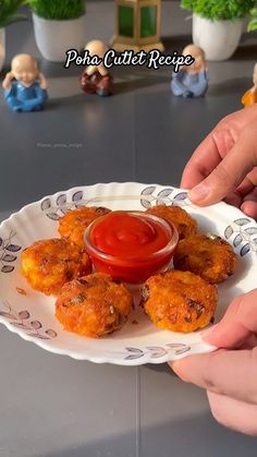 two hands holding a plate with fried food on it and dipping sauce in the middle