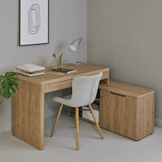 a wooden desk with two drawers and a chair next to it in front of a plant