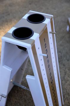 a cardboard box with two speakers attached to it sitting on the ground in front of a building