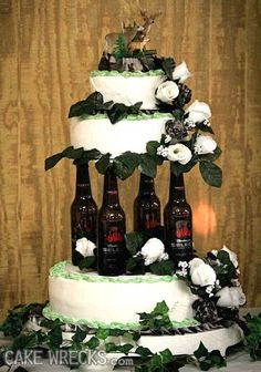 there is a wedding cake with beer bottles on it and greenery around the bottom