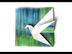 an origami bird on a green and blue background