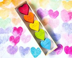 three heart shaped candies in a box on a colorful background